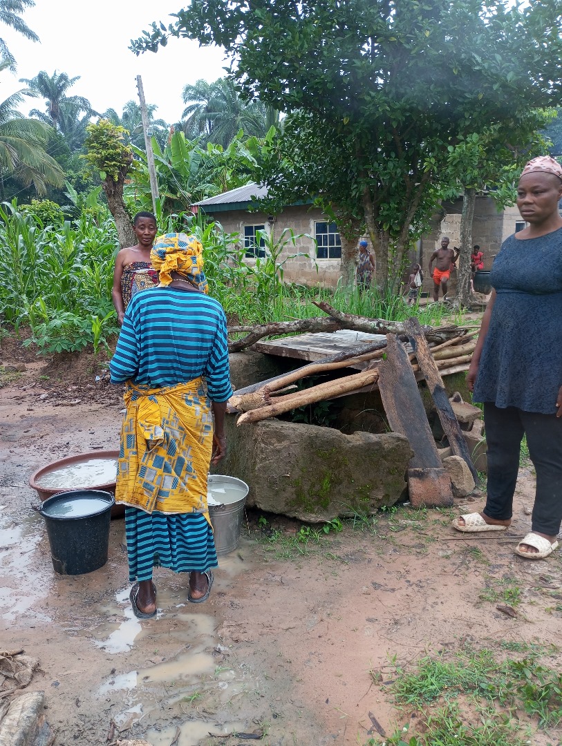 Women prepare an outdoor cooking fire to cook the yams.